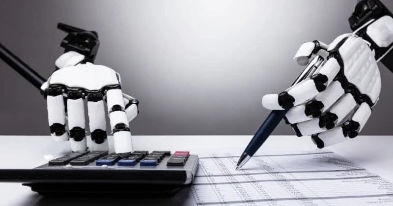 Robotic hands working a calculator and checking a ledger